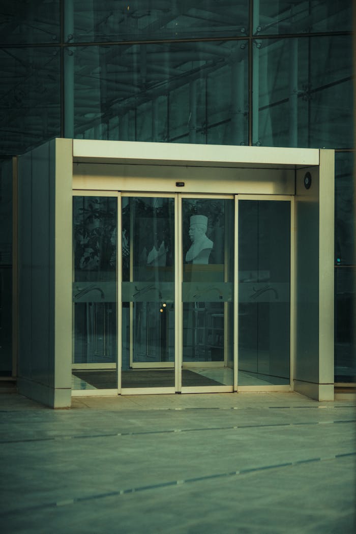 Glass entrance showcasing a modern bust, ideal for architectural and art themes.